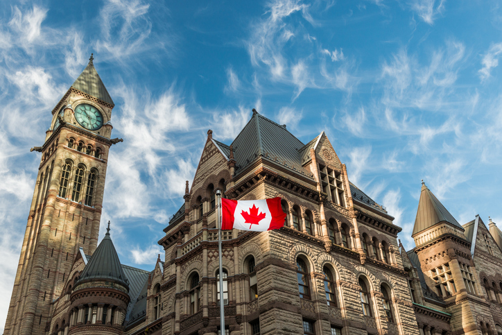 The Canadian flag flies before the Old City Hall, representing Securities Litigation in Toronto, Canada