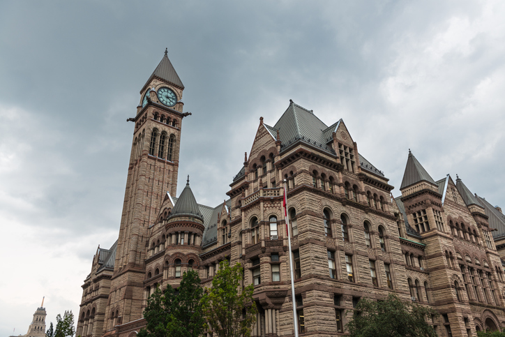 Wide-angle view of Toronto's Old City Hall against a cloudy sky.
